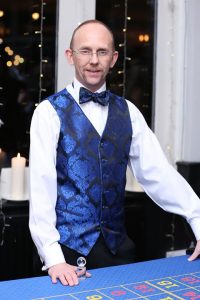Fun Casino Fun croupier in a blue waistcoat and bow tie at a casino table