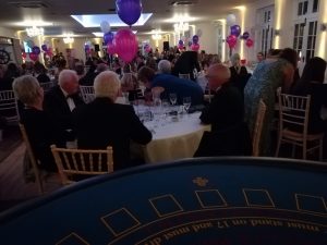 Casino table set up at a busy dinner party with balloons