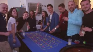 Group of young guests celebrating around a roulette table