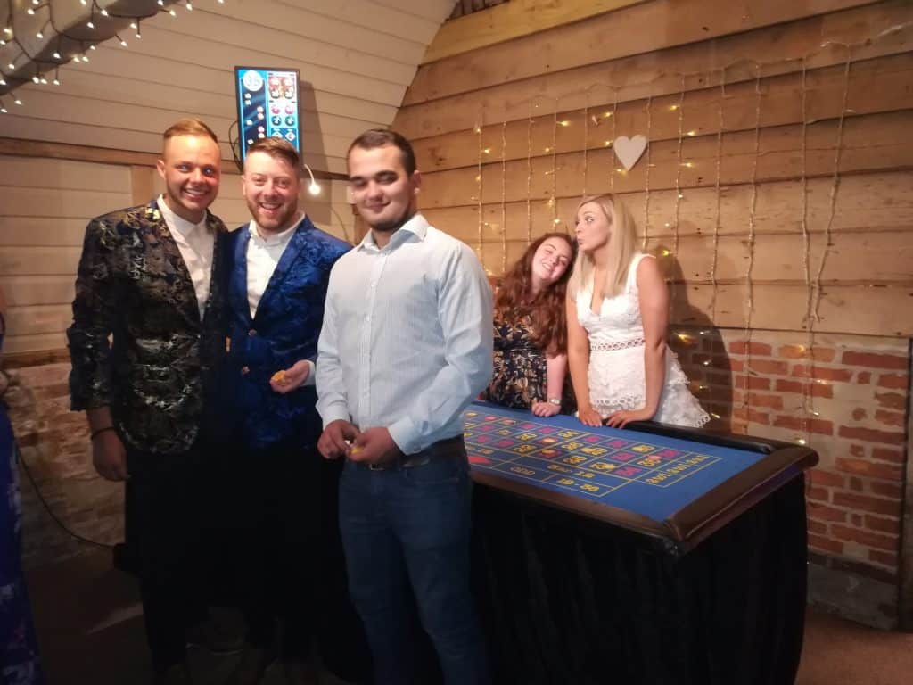 Wedding guests posing beside a Fun Casino Fun blackjack table