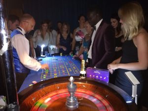 Guests around a roulette table at a black tie event