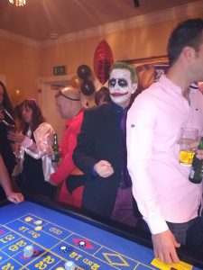 Halloween party guests in costume at a casino table