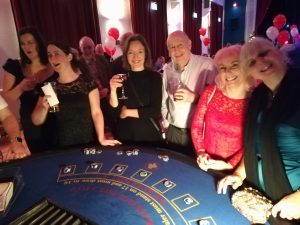 Group of guests in party dresses at a blackjack table