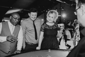 Guests laughing at a casino table, black and white photo