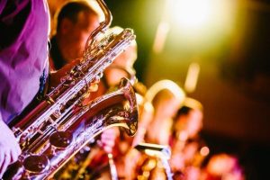 Saxophonists performing at an evening party under stage lights