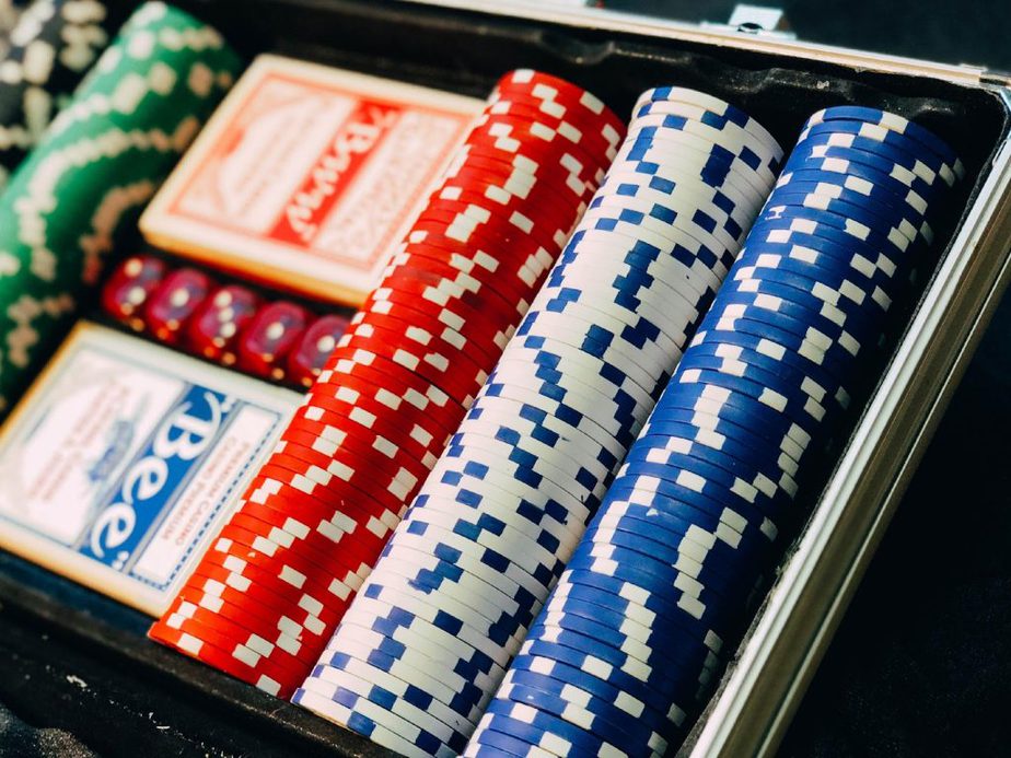Stacks of red, white and blue poker chips with playing cards in a chip case