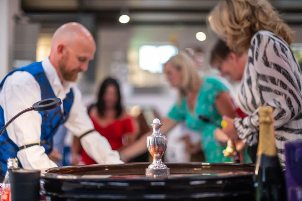 Croupier spinning the roulette wheel as guests place their bets