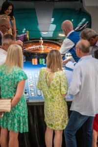 Guests in summer dresses at a roulette table