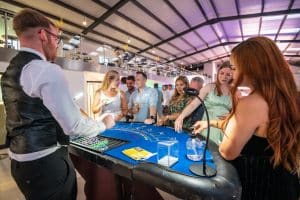 Croupier dealing blackjack to guests at a summer ball