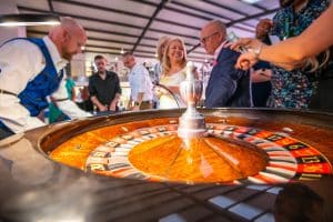 Croupier at the roulette wheel with players behind