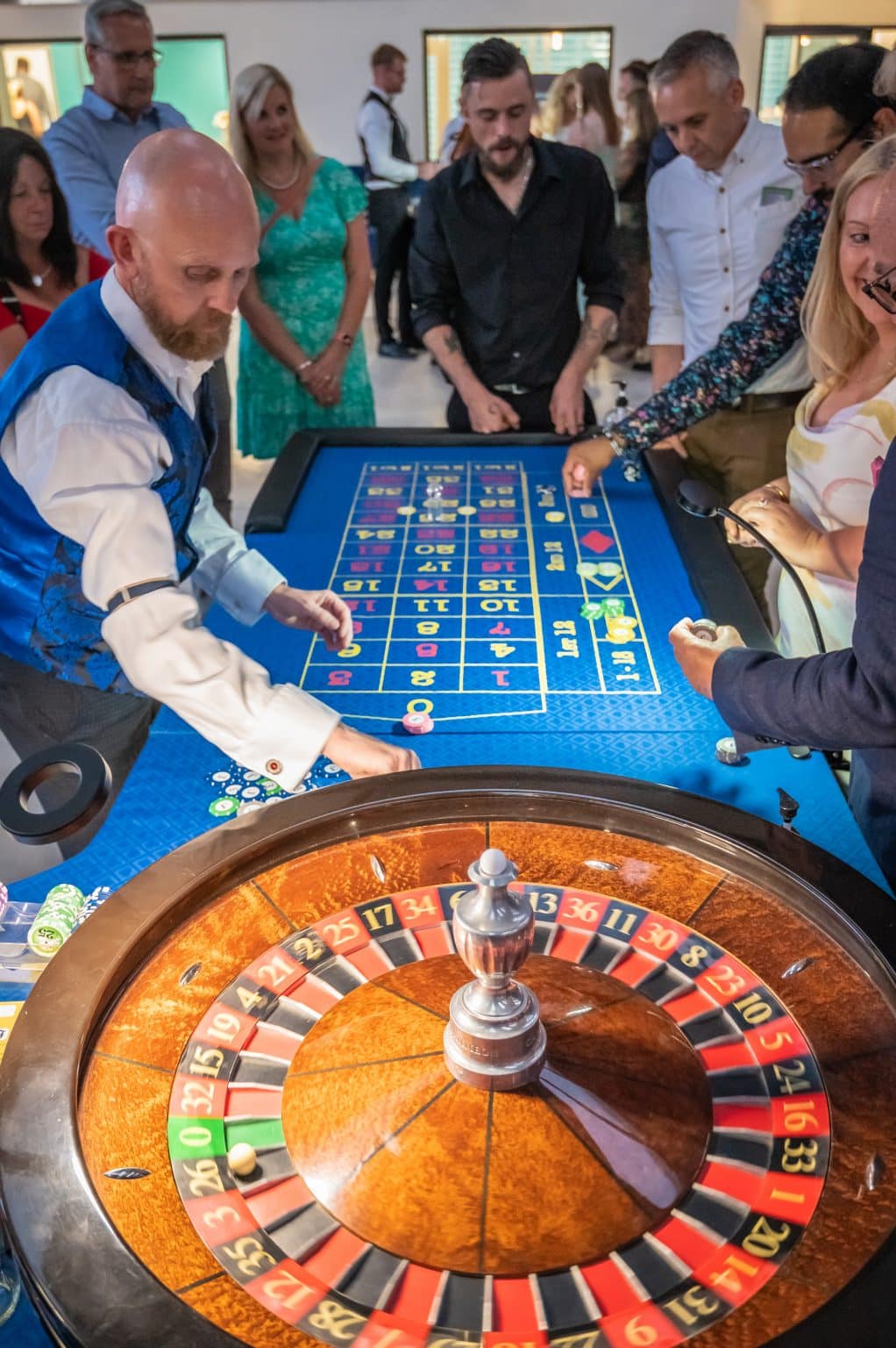 Roulette table in full swing with the wheel in the foreground