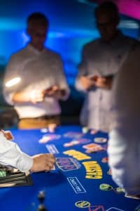 Dealer running a 3 Card Brag table under blue lighting