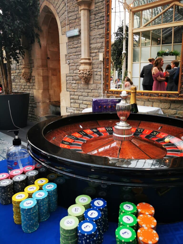 Roulette wheel and chip stacks set up at a wedding venue