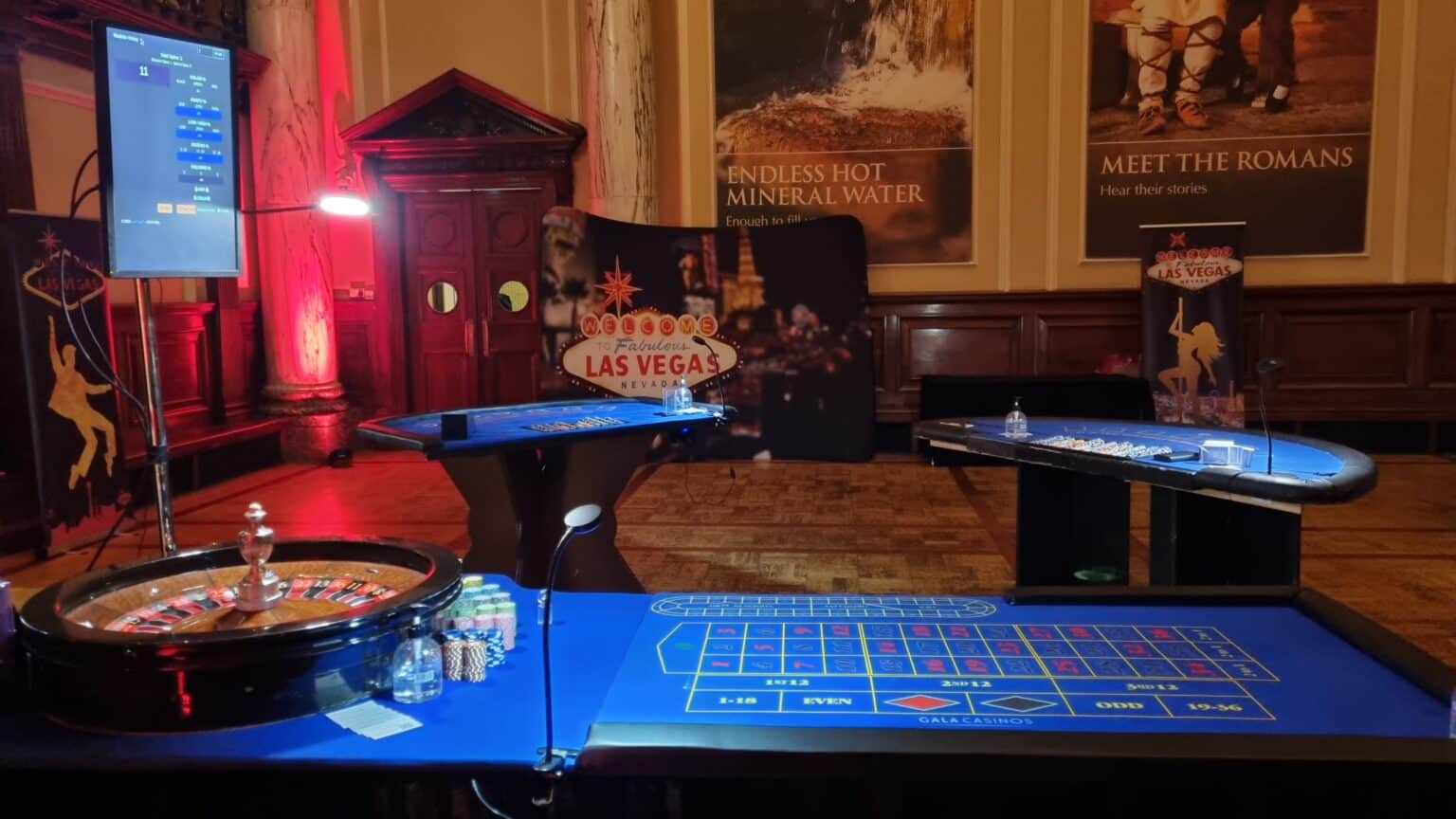 Roulette and blackjack tables with a Las Vegas backdrop in a historic hall