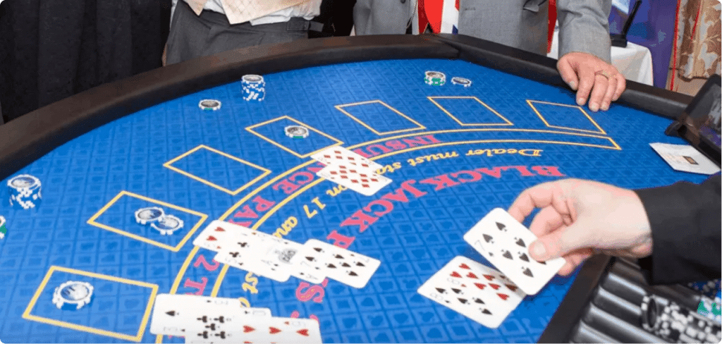 Croupier dealing cards on a professional blackjack table with chips on the betting spots