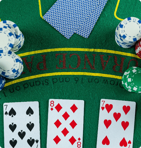 Cards and chips on a green 3 Card Brag table