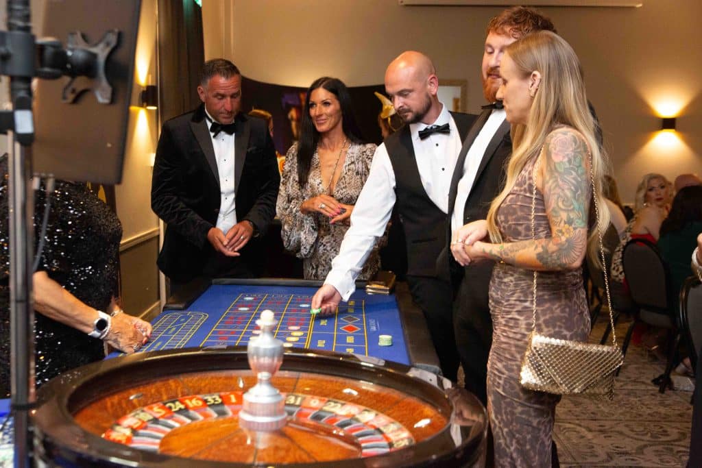 Croupier spinning roulette for guests in black tie