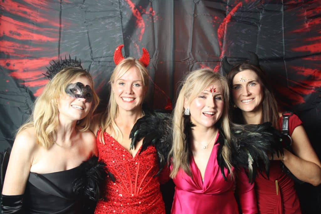 Friends having fun with photo booth props at a 40th birthday party