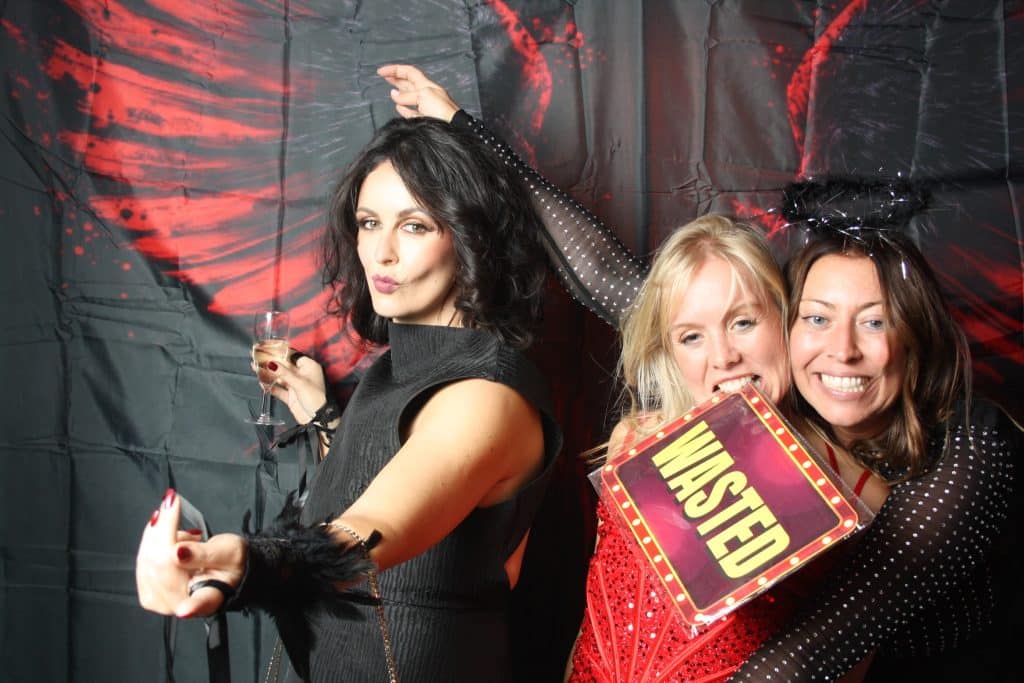 Guests wearing novelty props at a birthday celebration photo booth